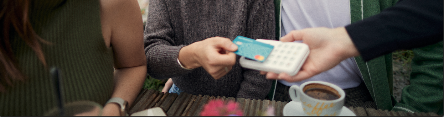 3 people, one paying wirelessly with her card